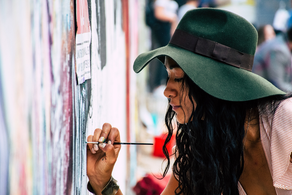 una persona con un sombrero verde y sosteniendo un pincel